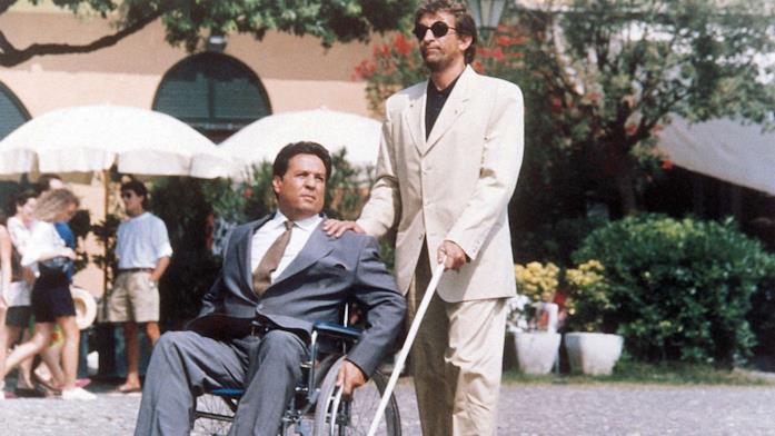 Fotogramma del film Infelici e contenti. Cieco che accompagna persona in sedia a rotelle